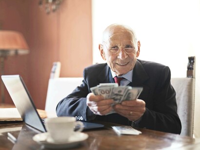An elderly man counting his money and demonstrating his value in the silver economy