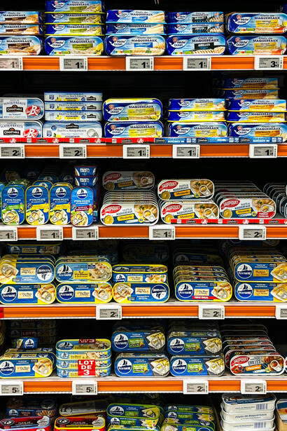 Rows of brightly packaged canned fish products displayed in a French supermarket, creating a vivid and organized retail scene, Le Touquet, Hauts-de-France, France