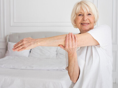 An elderly woman exercising in her bedroom, staying active and fit