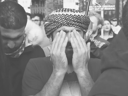 In October 2019, during a protest in London against the Turkish state's invasion of Syria, a compelling shallow-focus photograph captured a man wearing a white and black headdress among Kurdish demonstrators