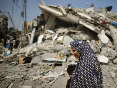 Una mujer palestina pasa junto a los escombros de un edificio residencial que, según la policía, fue destruido en un ataque aéreo israelí en la ciudad de Gaza el 22 de julio de 2014. Fotografía: Mohammed Salem