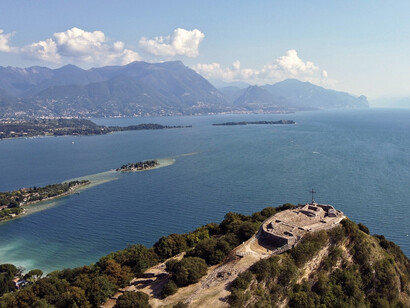 La Rocca di Manerba del Garda con l'isola dei Conigli, Wikipedia, foto di Guido Adler