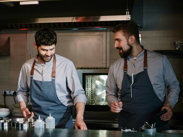 Two chefs work side by side in the kitchen of a luxury restaurant