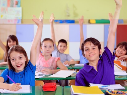 Niños con la mano levantada en clase