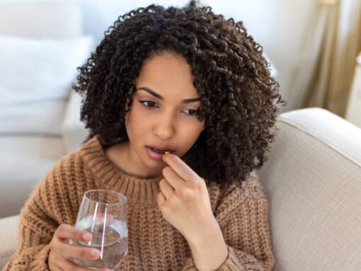 A young woman takes a supplement to support knee health and relieve joint discomfor