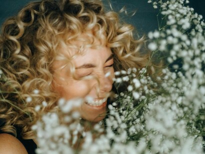 Mulher feliz com flores. A partir do significado básico de felicidade, os motivos que fazem uma pessoa feliz podem não ser os mesmos para outras, afinal, somos singulares e critérios culturais e sociais são envolvidos quando se trata da realidade de cada um. Neste ponto, entende-se que há motivos e critérios distintos para definir felicidade e, além disso, como se trata de um estado, é efêmero e transitório para todos