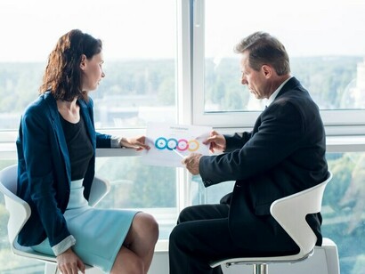 A coach reviewing an infographic with a client, mapping out the stages of the coaching journey, demonstrates the importance of persistence and smart strategies to navigate the challenges of building a successful business