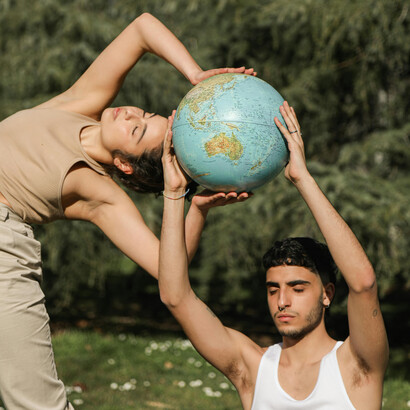 An artistic environmental portrait of a couple holding a globe in nature, reflecting balance, unity, and the shared bond between humankind and the planet
