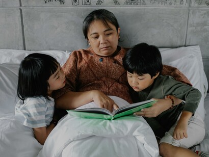 Mãe lendo para os filhos