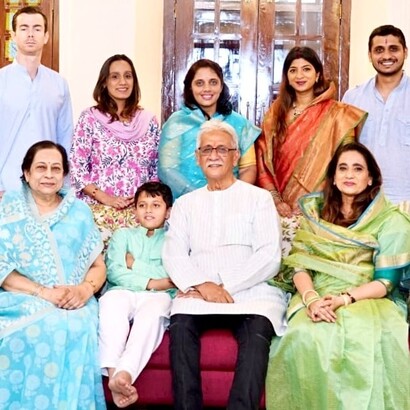 Nandita Ghatge, in sari verde chiaro, seduta accanto al marito Pravinsinh Ghatge di Kagal senior, posa con i suoi cari nella tenuta di campagna della famiglia