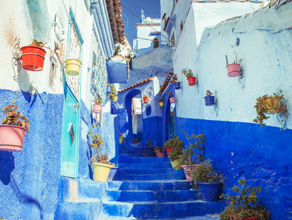 Blue concrete alley stairs in Chefchaouen, Morocco, showcasing the city's iconic architectural charm
