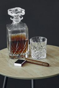 An engraved bottle of bourbon and a cigar, symbols of status