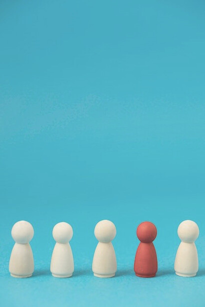 A group of pawns representing business roles, with one red pawn standing out to signify uniqueness