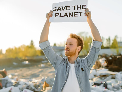A man passionately holds a piece of paper with the words 'save the planet,' expressing his dedication to the environmental movement and the fight against environmental damage, pollution, and climate change