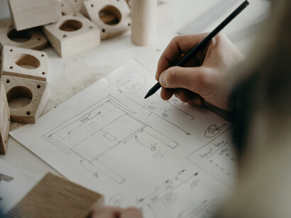 A person drawing the plans for a building, capturing the creativity that turns concepts into contextual spaces