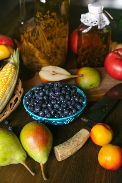 Frutas frescas e vegetais dispostos sobre uma mesa destacam a diversidade dos alimentos naturais. Nutrientes e compostos bioativos presentes nesses alimentos participam de processos associados à regulação epigenética