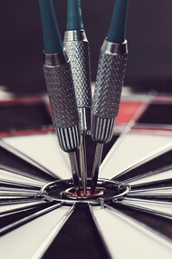 Darts hitting the bullseye, symbolizing success