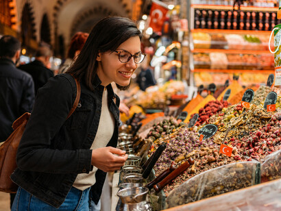 A woman exploring a traditional spice shop at the Grand Bazaar in Istanbul, Turkey