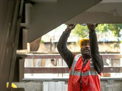 Un professionnel du secteur de la construction effectuant un travail de précision, illustrant l’importance de protéger les travailleurs dans une économie en mutation