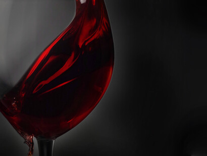 Some red wine from Great Britain is being poured slickly into a glass