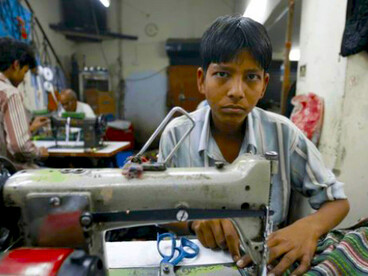 A young boy works in a textile factory in Delhi, India
