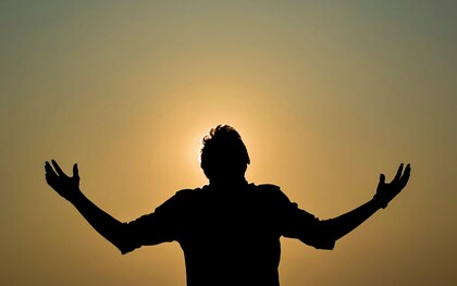 A silhueta de um homem ergue os braços diante do céu dourado do entardecer, em um gesto que sugere abertura e renovação. Depois de refletir sobre a força das tristezas e das lembranças que permanecem, o autor encontra na possibilidade de recomeçar a cada dia uma nova chance de ser feliz