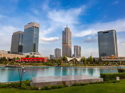 Contemporary architecture reflected in a pool at Tashkent City Park, Uzbekistan