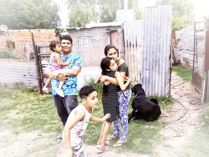 Dario Almiron stands with his family outside their home in the Villa Gobernador Galvez district on the outskirts of Rosario, Argentina, South America