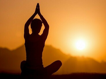 A practitioner embracing the dawn through meditation, representing the cultivation of awareness and inner peace
