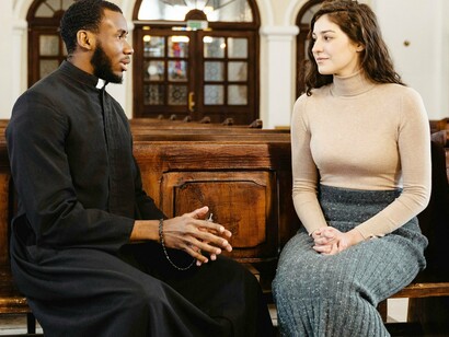 Mulher se aconselha com padre. A conversão ao cristianismo era frequentemente associada à lealdade às autoridades coloniais, e a Igreja desempenhava um papel central na legitimação da dominação colonial. Autores como Inga Clendinnen argumentam que a conversão não era apenas um processo espiritual, mas uma estratégia política para integrar as populações indígenas ao sistema colonial