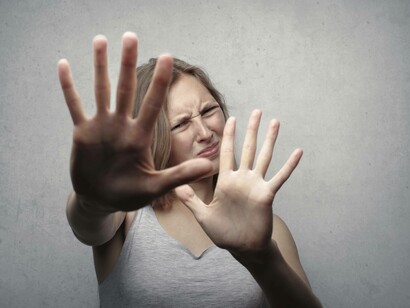 A woman sticking her palms out of fear for what might come
