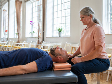 A senior practitioner leading a therapeutic movement session focused on embodiment, nervous system awareness, and holistic mind-body healing through the Feldenkrais Method