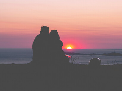 Sagoma di un abbraccio al tramonto: la gioia di fronte a un sorriso o a un abbraccio inatteso