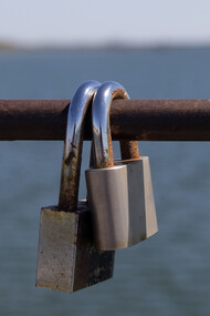 Dos candados en la baranda de un puente, símbolo del compromiso