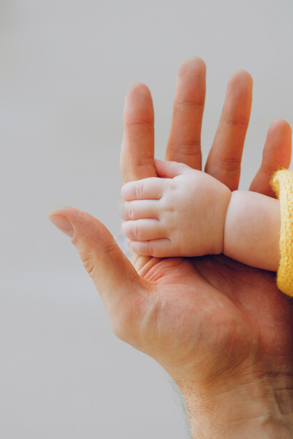 La pequeña mano de un bebé sobre la de su padre