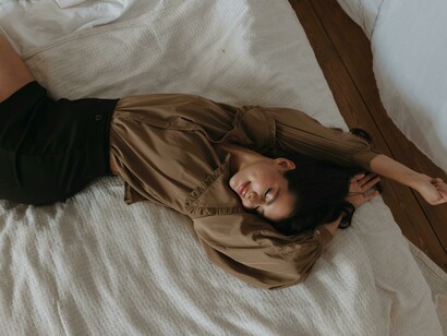 A quiet moment of reflection: a person smiling in bed, symbolizing identity, self-discovery, self-acceptance, and emotional honesty