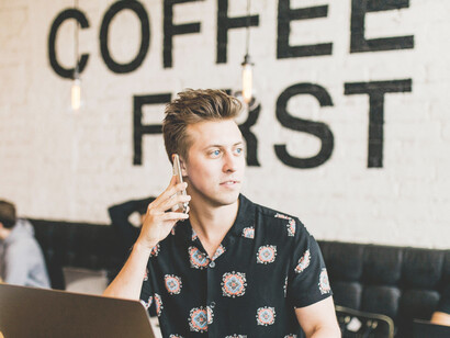 In a cozy café, a man concentrates on his laptop, immersed in work