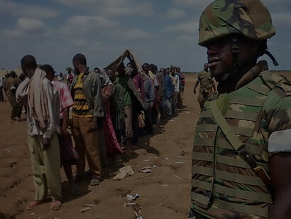AMISOM soldier observes as over 200 Al Shabaab fighters surrender near Jowhar, Somalia, after internal clashes resulting in the deaths of 8 militants, including 2 senior commanders