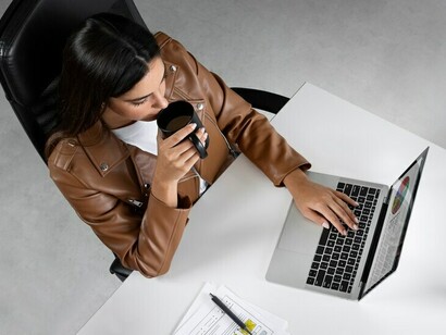 Top-view shot of a female journalist working on her laptop, actively engaged in reporting
