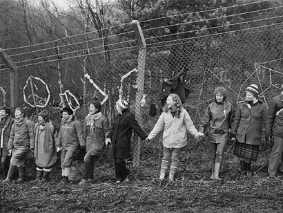 © Edward Barber 
‘Embrace the Base’: 30,000 women link hands, completely surrounding the nine mile perimeter fence at RAF/USAF Greenham Common, Berkshire (1982)

