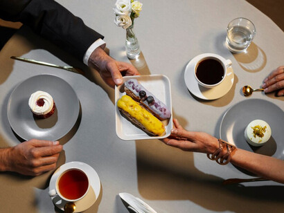 A top view of friends enjoying a bottomless brunch at a luxury restaurant, featuring brunch cocktails, prosecco, and a delicious spread of food and drinks on the table