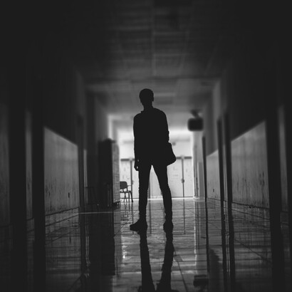 Usando una bata de paciente, se sentó en la sala de emergencias con los demás que estaban allí