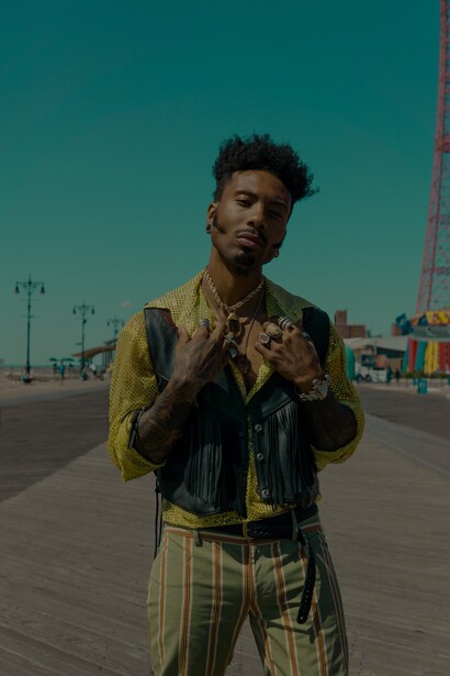 Jovem veste calça verde musgo listrada estilo vintage com camisa de lantejoulas e colete de couro