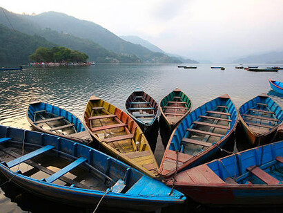 Colorful boats on Phewa Lake in Nepal, a freshwater lake in the Pokhara Valley that spans Pokhara city and extends toward Sarangkot and Kaskikot