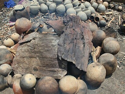 Vasijas de greda y barro colocadas alrededor de un fuego ardiente