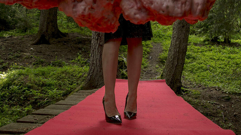 'Avant/Après', video Installation 01, 2014/15, bizarre imagery of an unsuitably dressed luxury tourist in a cocktail dress and high heels searching for the VIP area on the Swiss mountains equipped with a red carpet, vip gold poles and an intestine rope. Strange scenes highlighting this innermost struggle, the exhaustion and desire to belong.