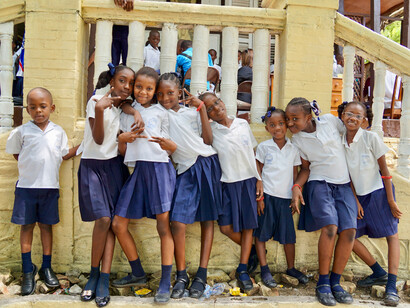 Rires et espoirs : des enfants haïtiens vêtus de leurs uniformes scolaires, symbolisant l'avenir du pays et la résilience face aux défis quotidiens