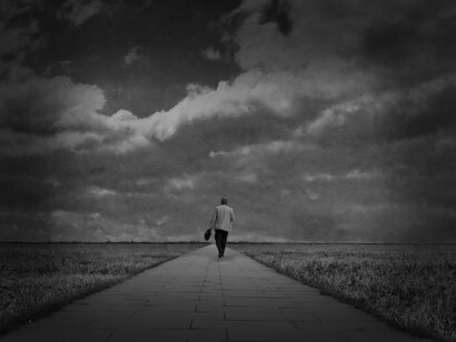 A man walking alone on a path in a field, questioning and overcoming his limits