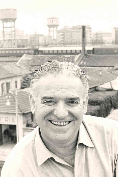 Fotoritratto dello scrittore Pier Angelo Soldini con un paesaggio urbano alle spalle
