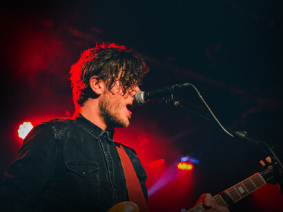 Músico canta mientras toca la guitarra. La primera impresión que ofrece un artista al aparecer en el escenario marcará las expectativas del resto del espectáculo